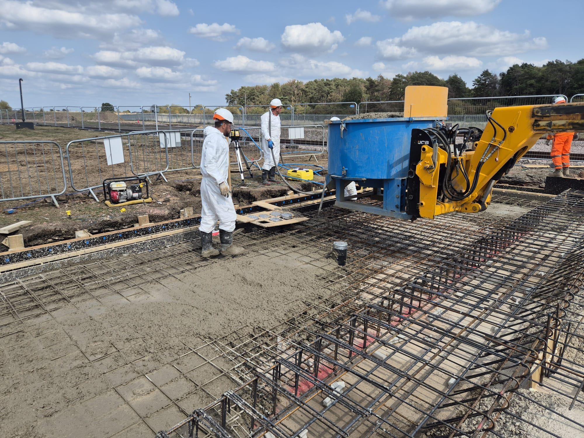 Concrete being discharged from a machine mounted skip onto a reinforced raft during a pour