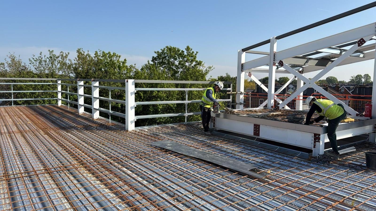 Workers fixing reinforcement over metal decking on an elevated composite floor slab